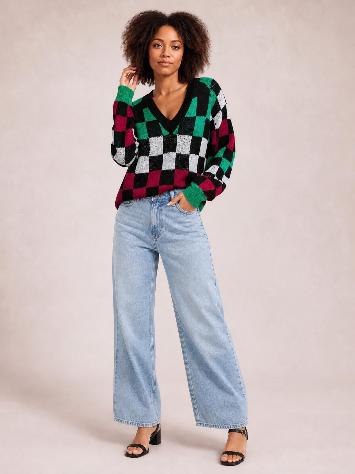 Model poses in a colorful checkered V-neck sweater with voluminous lantern sleeves, ribbed cuffs, and a relaxed silhouette.