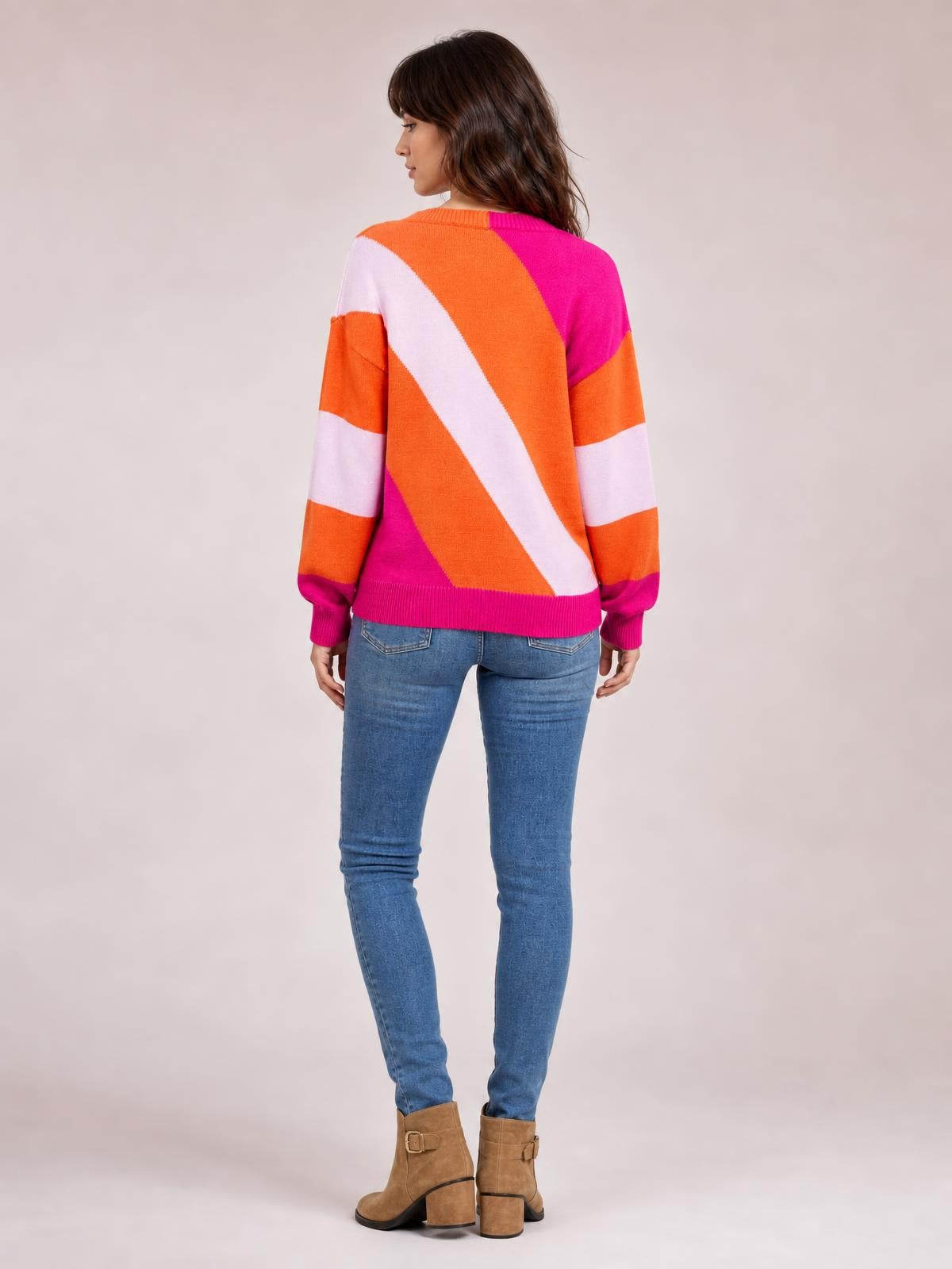 Model shown from behind wearing a color block ribbed round neck sweater in orange, pink, and white with long sleeves and a regular silhouette.