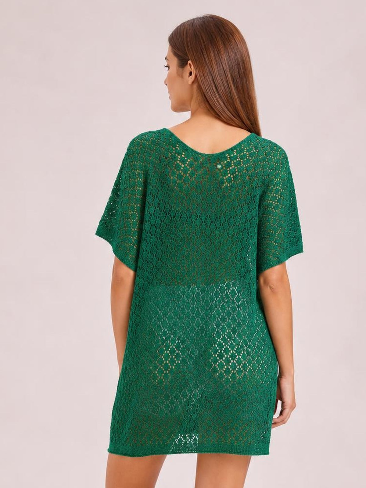 A model poses from the back in a green semi-sheer openwork cover up with a scoop neckline, short sleeves, and a relaxed straight silhouette.