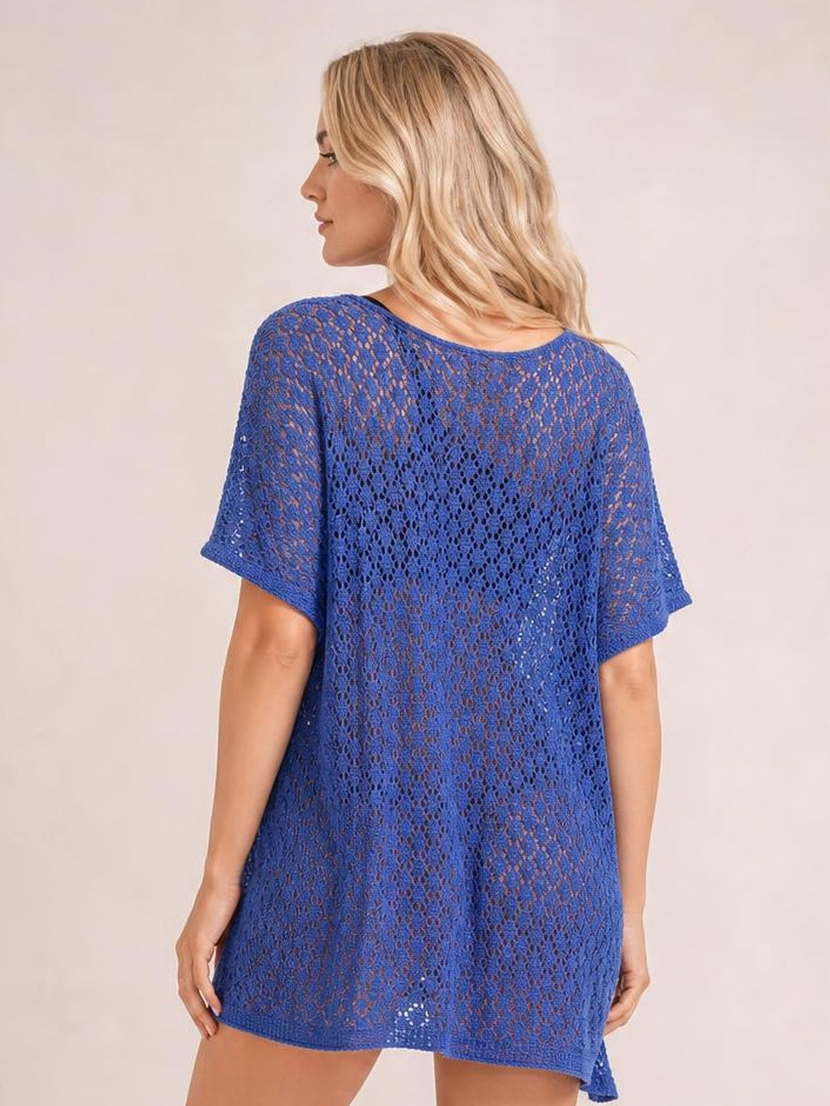 A model poses in a royal blue semi-sheer openwork cover up, shown from the back with a scoop neckline, short sleeves, and a relaxed, loose-fitting silhouette.