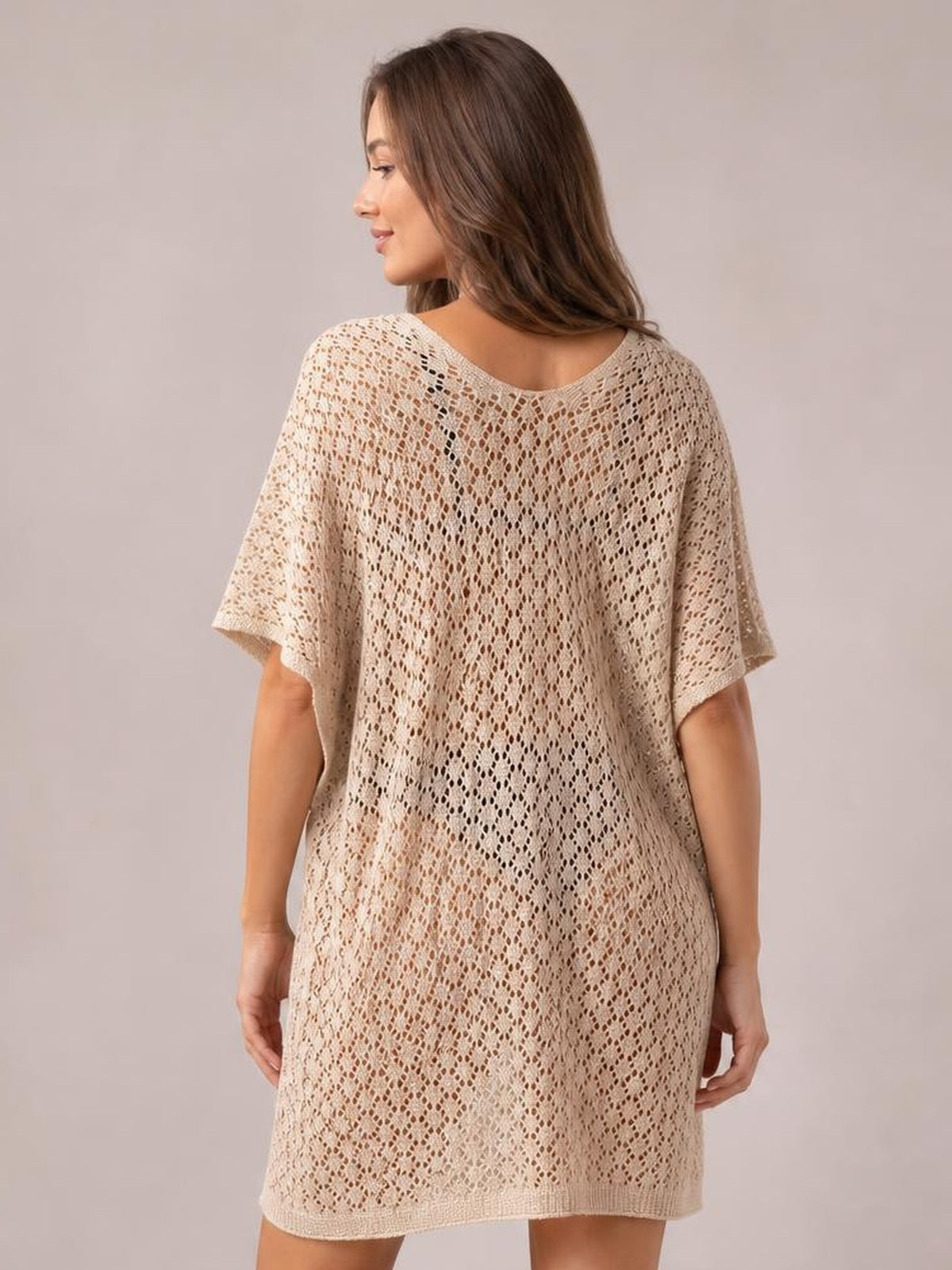 Model shown from behind in a cream openwork cover up with a scoop neck, short sleeves, semi-sheer relaxed silhouette, and straight hem.