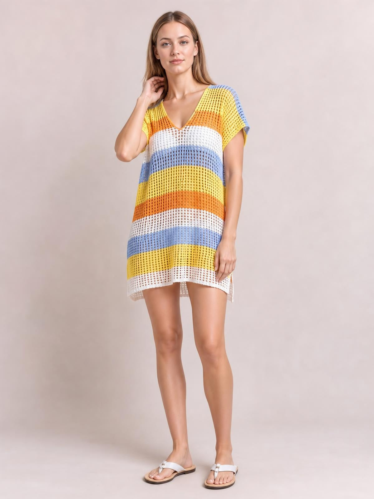 Model poses in a colorful striped V-neck short-sleeve cover-up with semi-sheer openwork, a relaxed straight silhouette, and a slightly uneven hem.