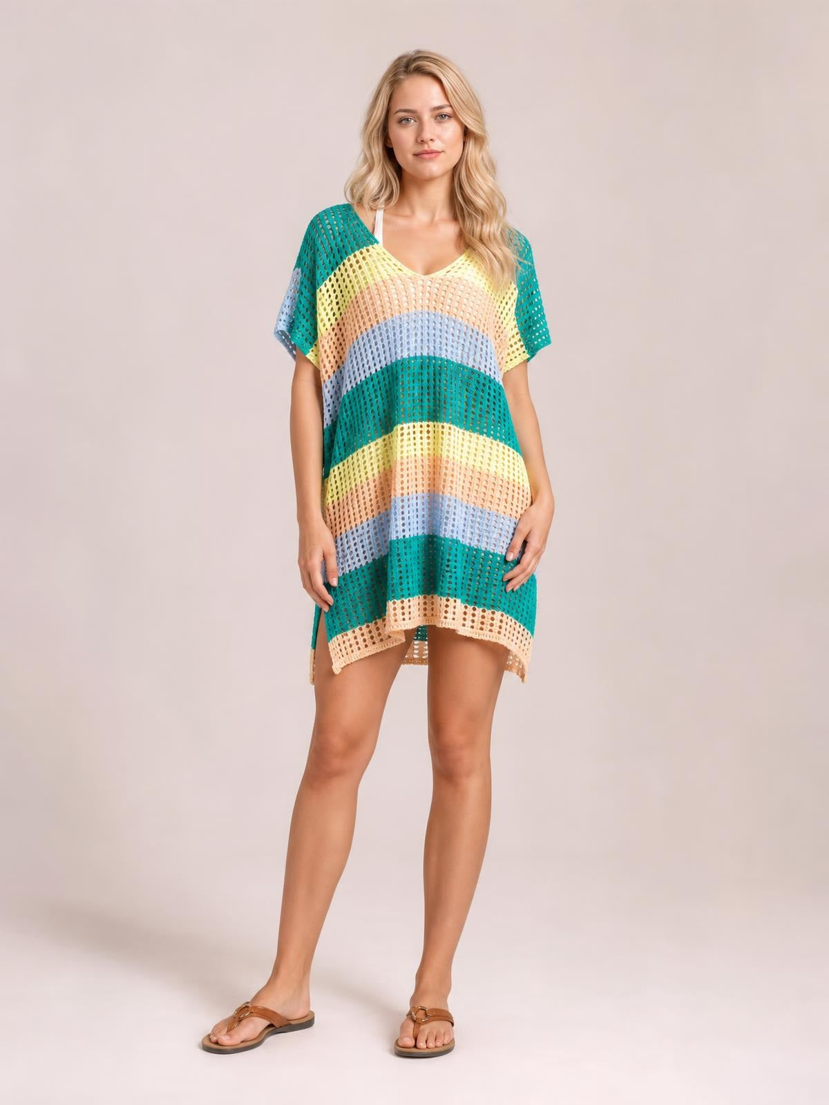 Model stands in a relaxed, multicolor striped V-neck short-sleeve cover-up with semi-sheer openwork, an airy oversized silhouette, and a curved hem.