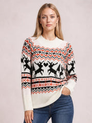 Model wearing a cream round-neck long-sleeve reindeer sweater with a relaxed silhouette, ribbed cuffs and hem, and black and red patterned knit bands.