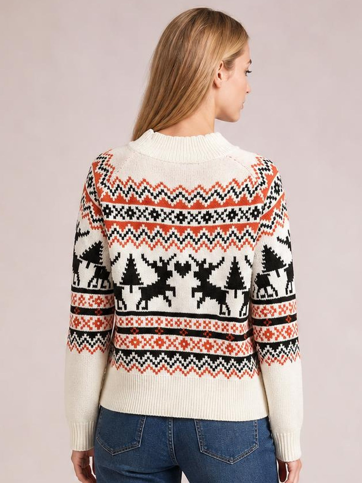 Back view of a woman wearing a cream reindeer round neck long sleeve sweater with red and black winter motifs, ribbed cuffs, collar, and hem.