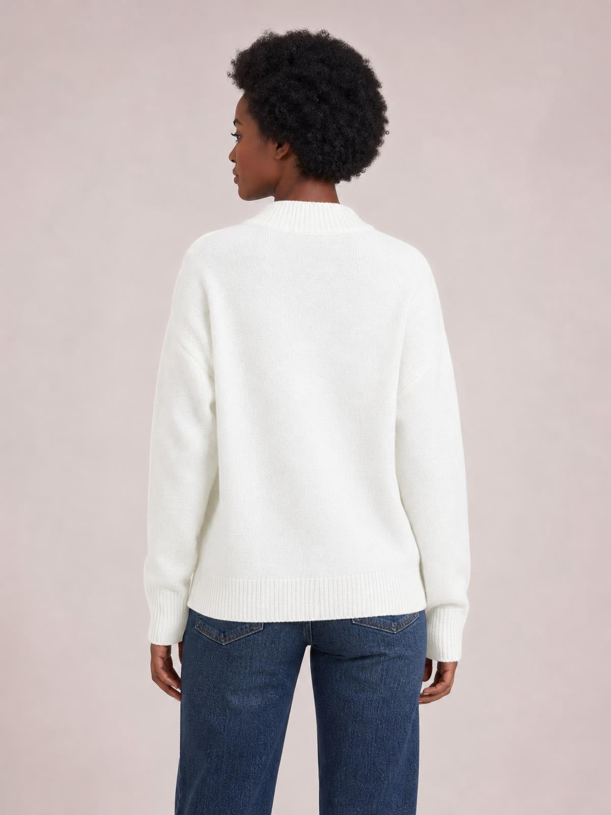 Model viewed from behind wears a solid white ribbed sweater with a round neck, long regular sleeves, ribbed cuffs and hem, and a regular-length silhouette.