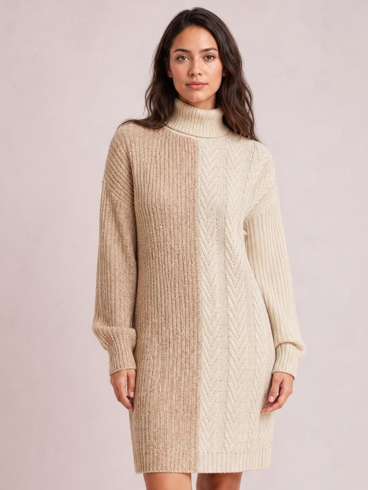 Model wears a beige and cream color block turtleneck sweater dress with ribbed knit panels, long sleeves, and a relaxed knee-length silhouette.