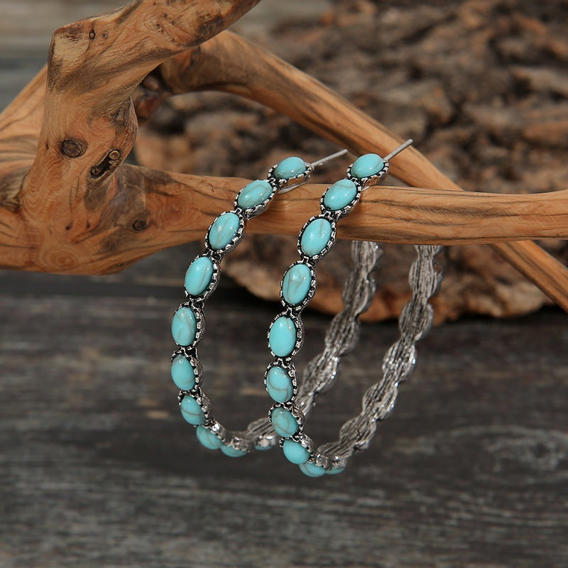 Artificial turquoise C-hoop earrings feature a curved drop silhouette with oval turquoise accents set in textured alloy frames for a distinctive statement look.