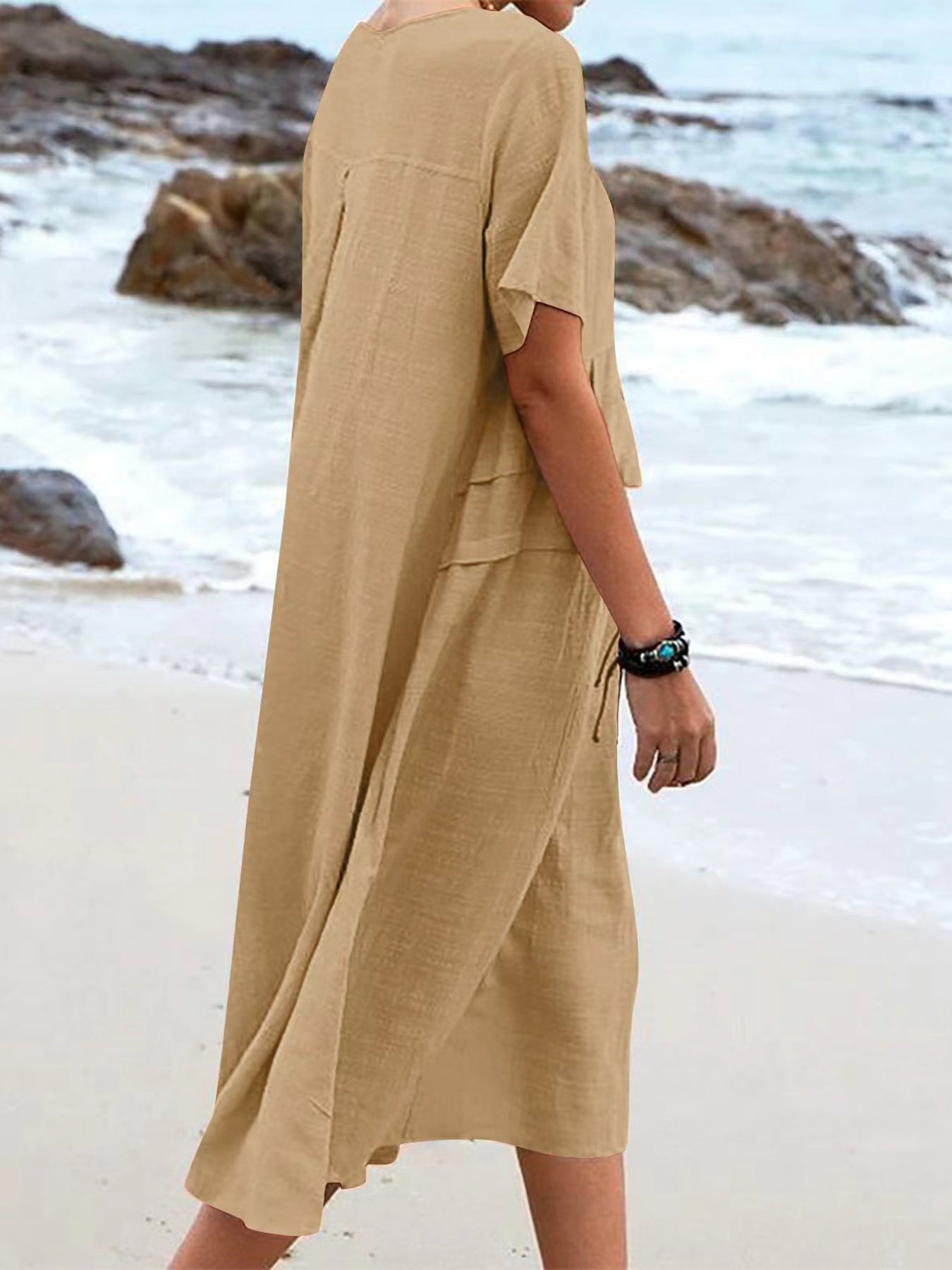 Plus size loose midi dress with short sleeves and pockets shown in cream and black by the beach