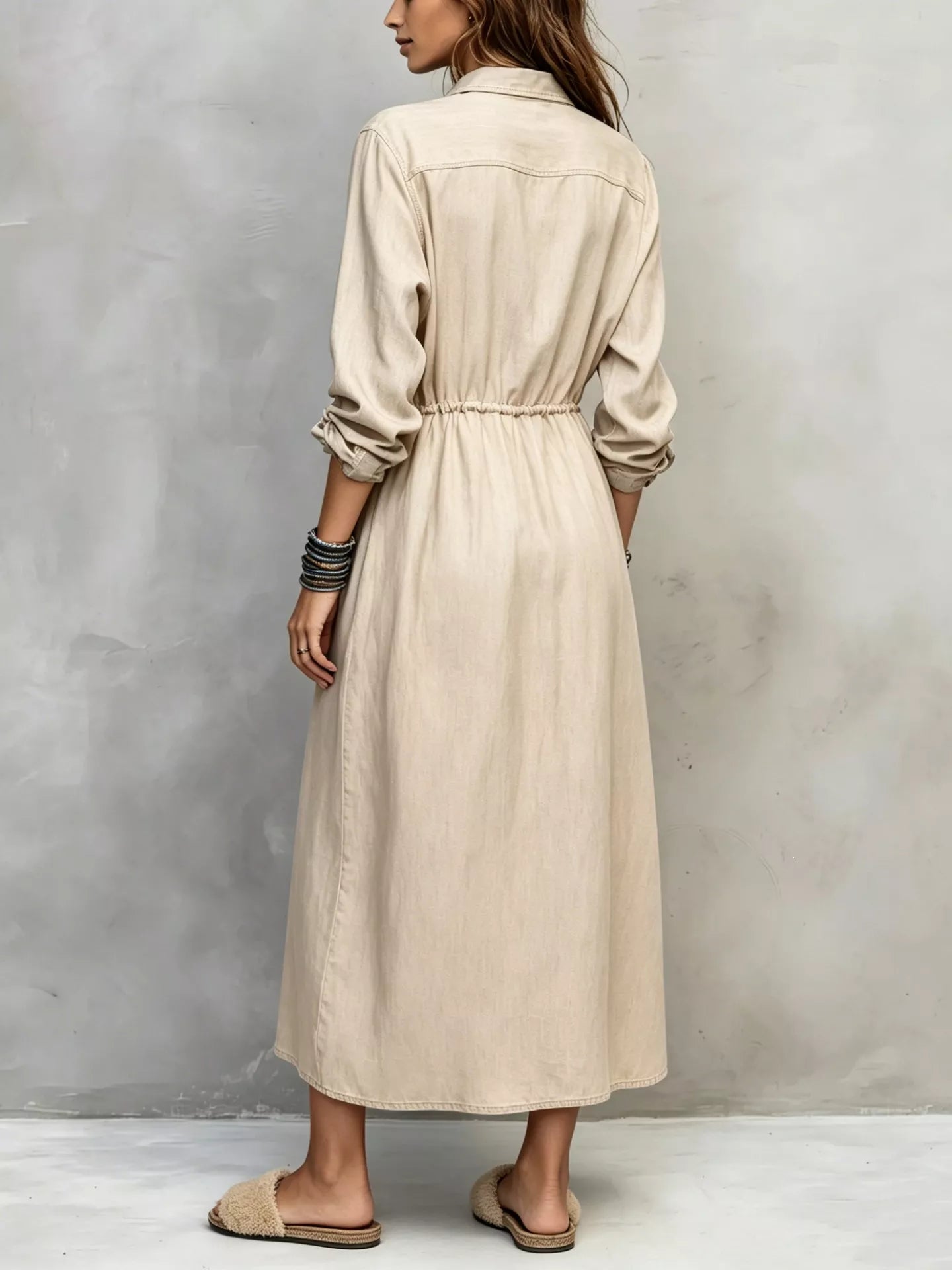 Plus size blue button-front shirt dress with long sleeves, drawstring waist, pockets, and side slit