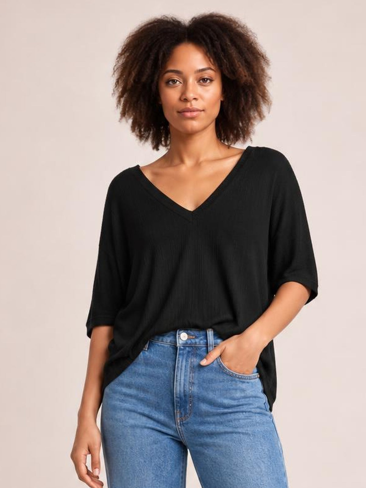 Model wearing a black Bamboo V-neck drop shoulder T-shirt with a relaxed oversized silhouette, short sleeves, and a slightly curved hem.