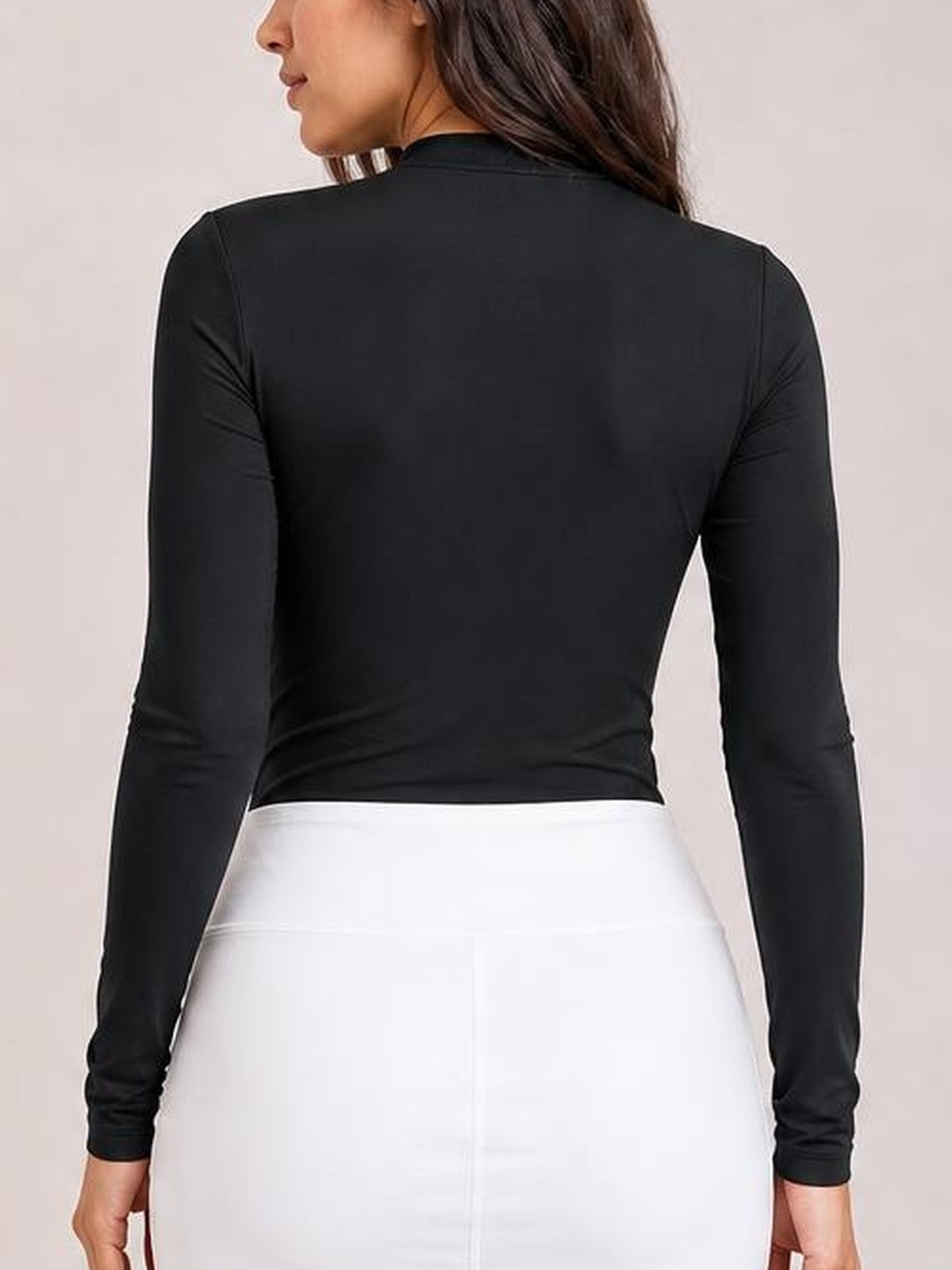 Model shown from behind wearing a black mock neck long sleeve bodysuit with a fitted silhouette, smooth opaque fabric, and moderate stretch.