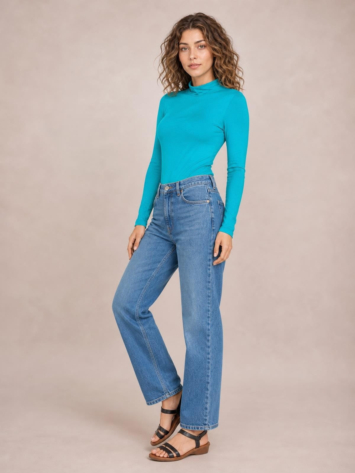 A model poses with one leg bent in a bright turquoise mock neck long sleeve bodysuit featuring a fitted silhouette and smooth opaque construction.