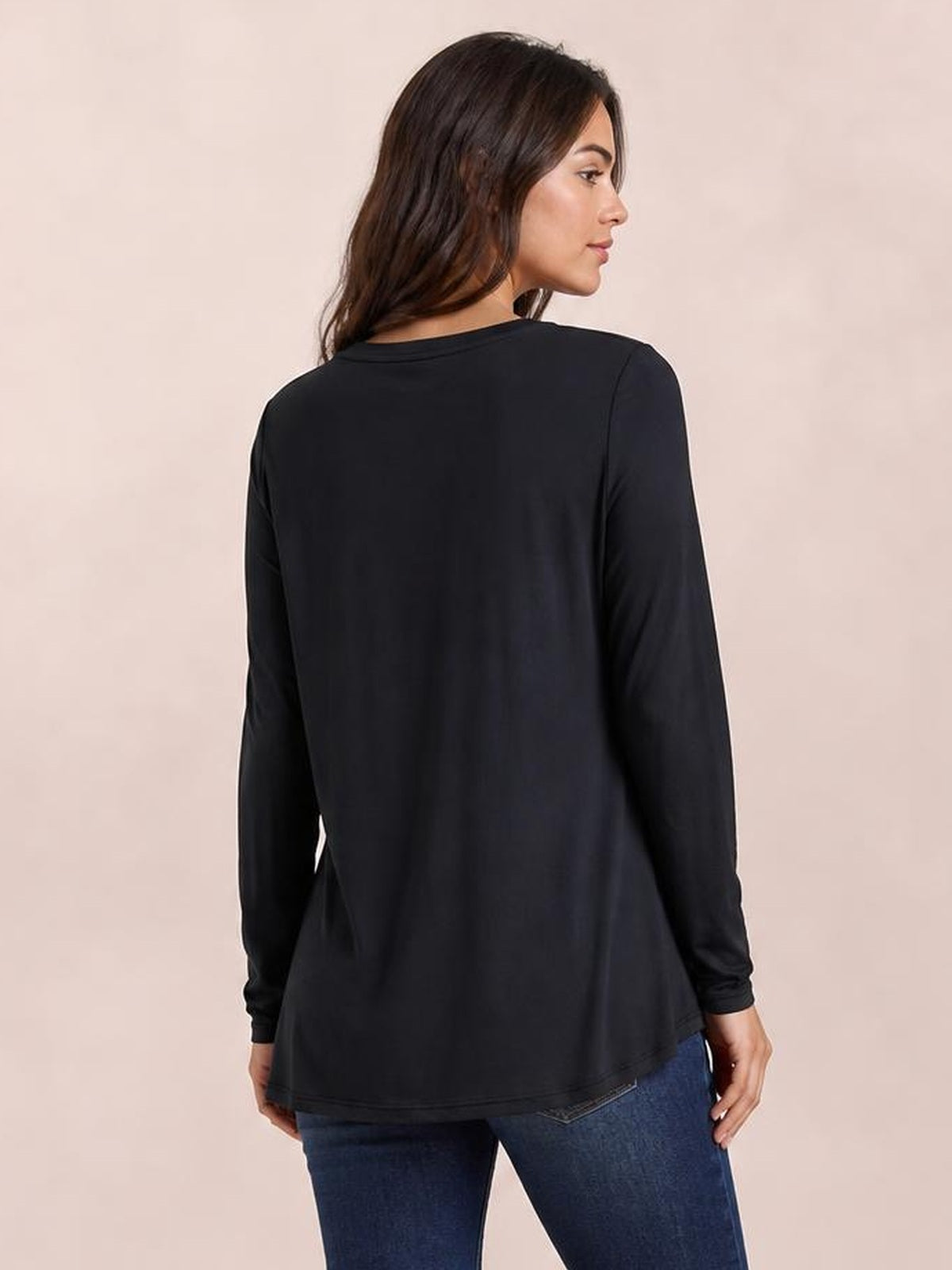 Model shown from the back in a black round neck long sleeve top with a relaxed, slightly flared silhouette and smooth opaque construction.