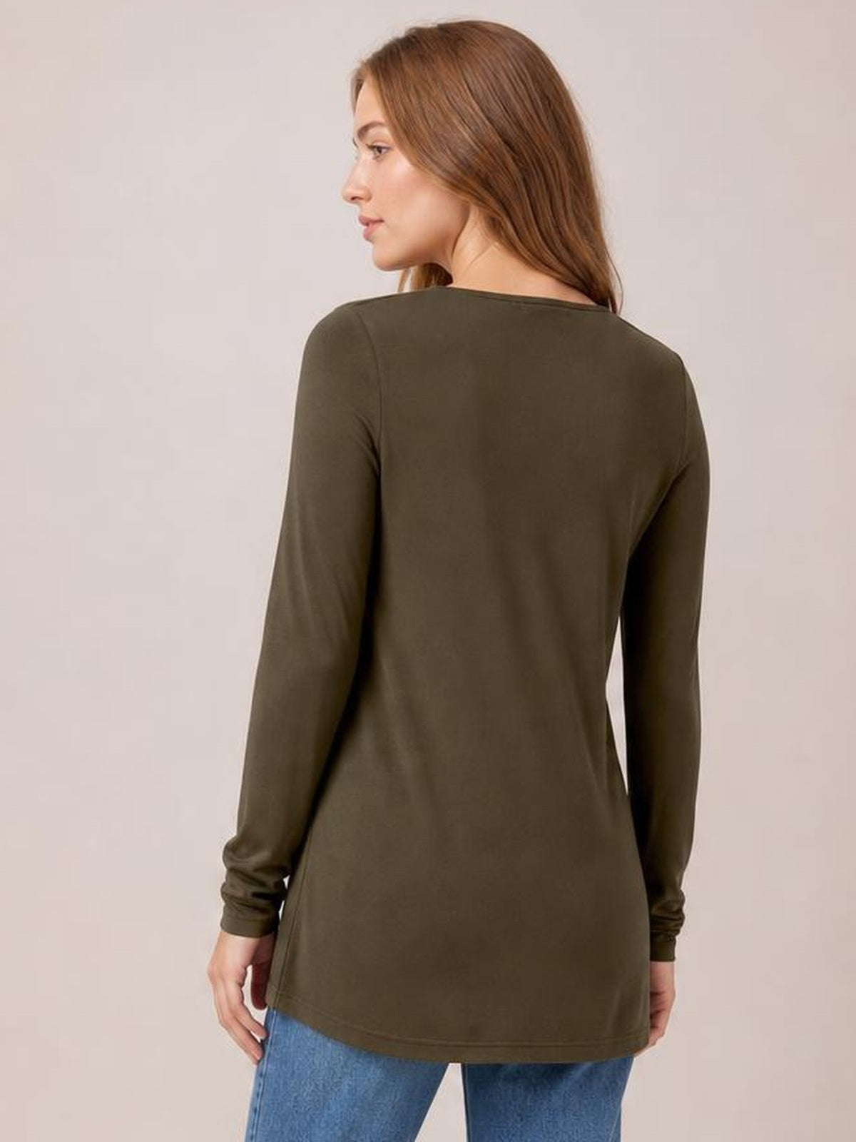 A model turns to show the back of an olive round neck long sleeve top with a relaxed, straight silhouette and softly gathered cuffs.