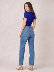 A model poses turned away in a cobalt blue round neck short sleeve bodysuit, showing its smooth, fitted silhouette and close-cut construction.