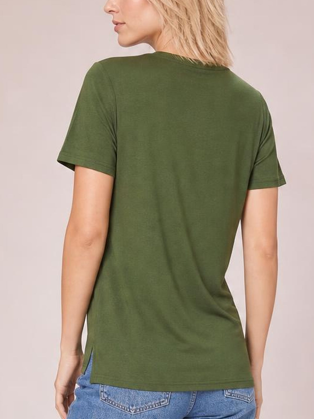 A model shown from behind wears an olive green high-low T-shirt with short sleeves, a relaxed silhouette, longer back hem, and side slit.