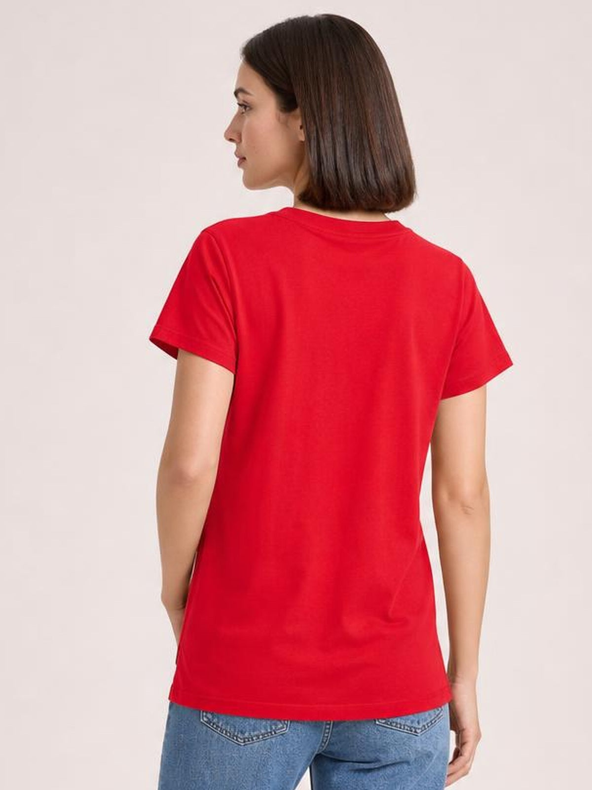 Model shown from behind wearing a bright red high-low T-shirt with short sleeves, a relaxed silhouette, and a softly draped opaque construction.