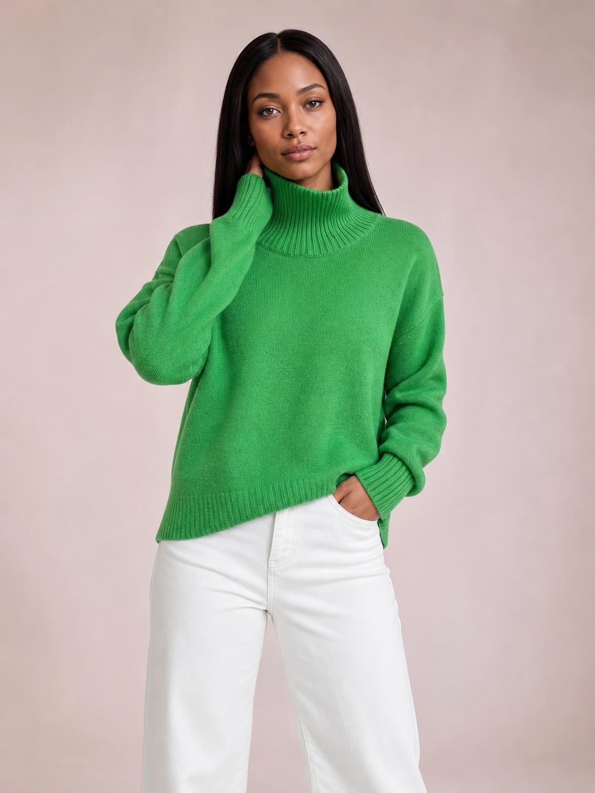 Model wearing a bright green turtleneck long sleeve sweater with dropped shoulders, ribbed cuffs and hem, and a relaxed silhouette.