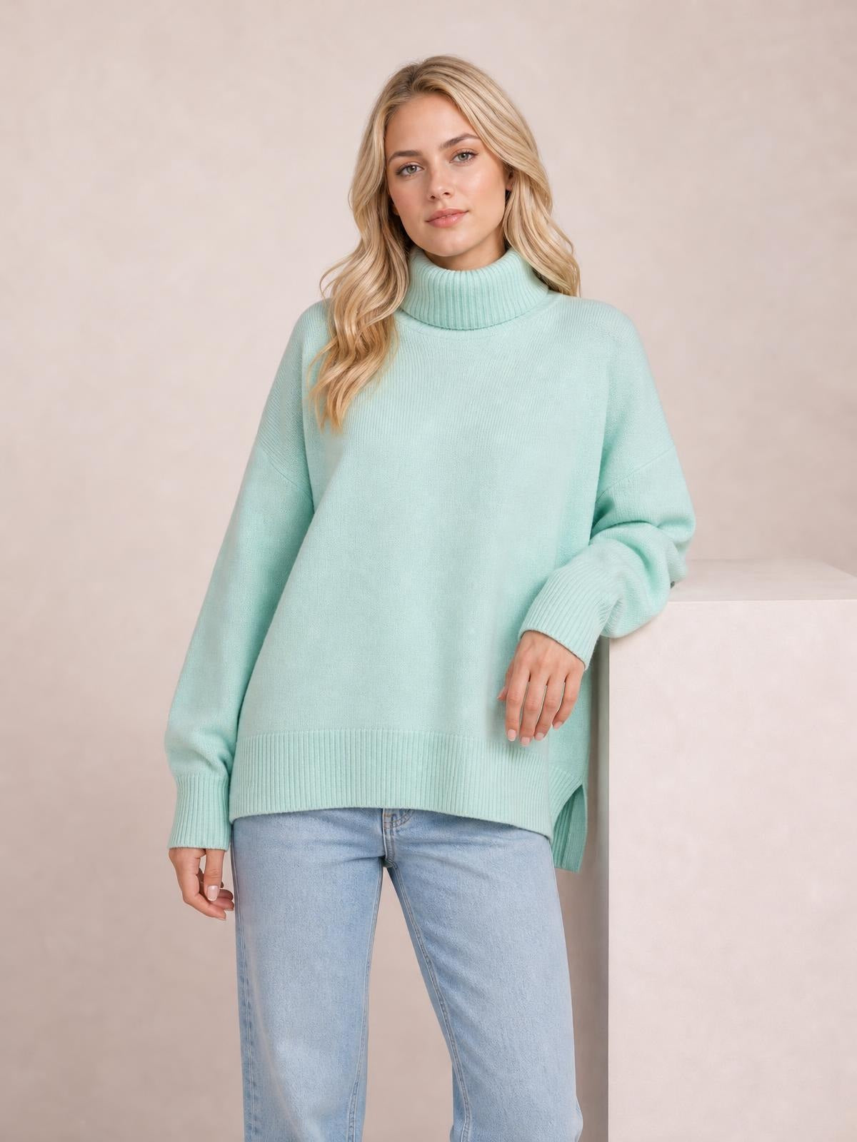 Model wears a mint green turtleneck dropped-shoulder long-sleeve sweater with an oversized silhouette, ribbed collar, cuffs, and hem.