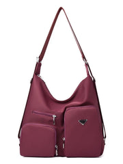 Burgundy lightweight nylon shoulder bag with a slouchy silhouette, long adjustable strap, silver hardware, and multiple front zippered pockets.