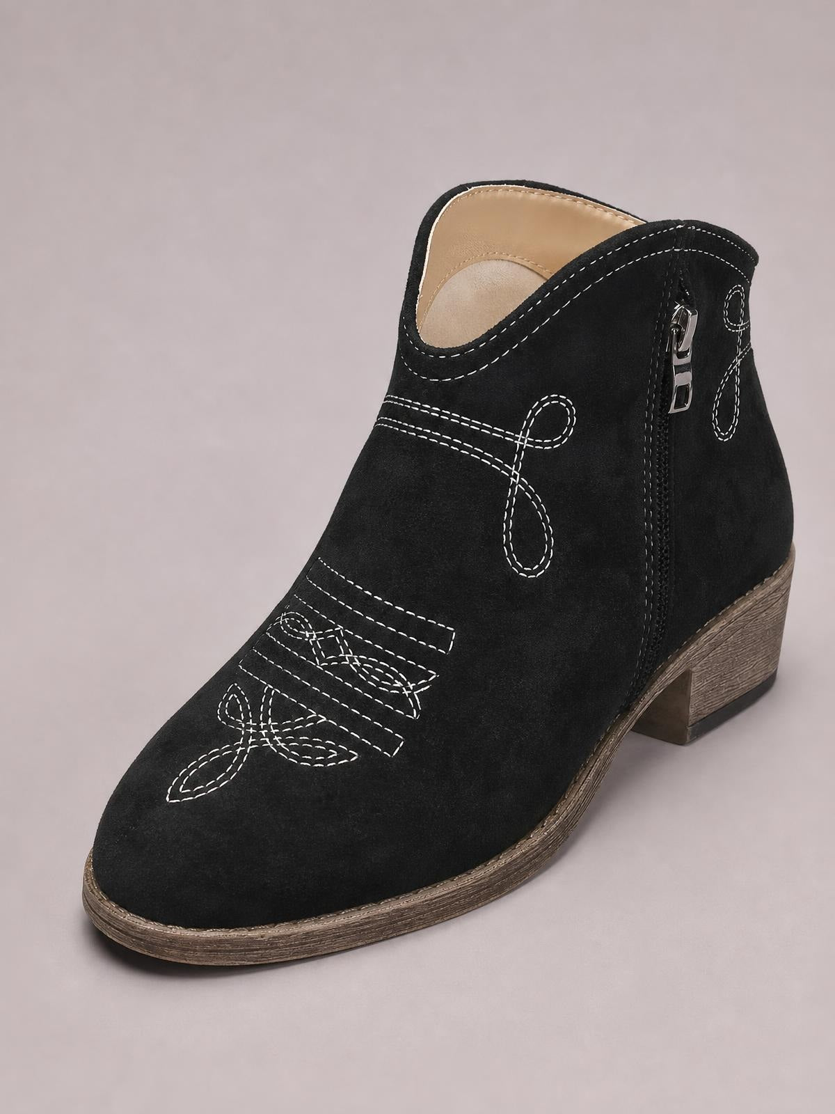Black PU leather ankle boot with a rounded toe, contrast white stitching, side zipper, decorative seams, and a mid-height wood-look block heel.