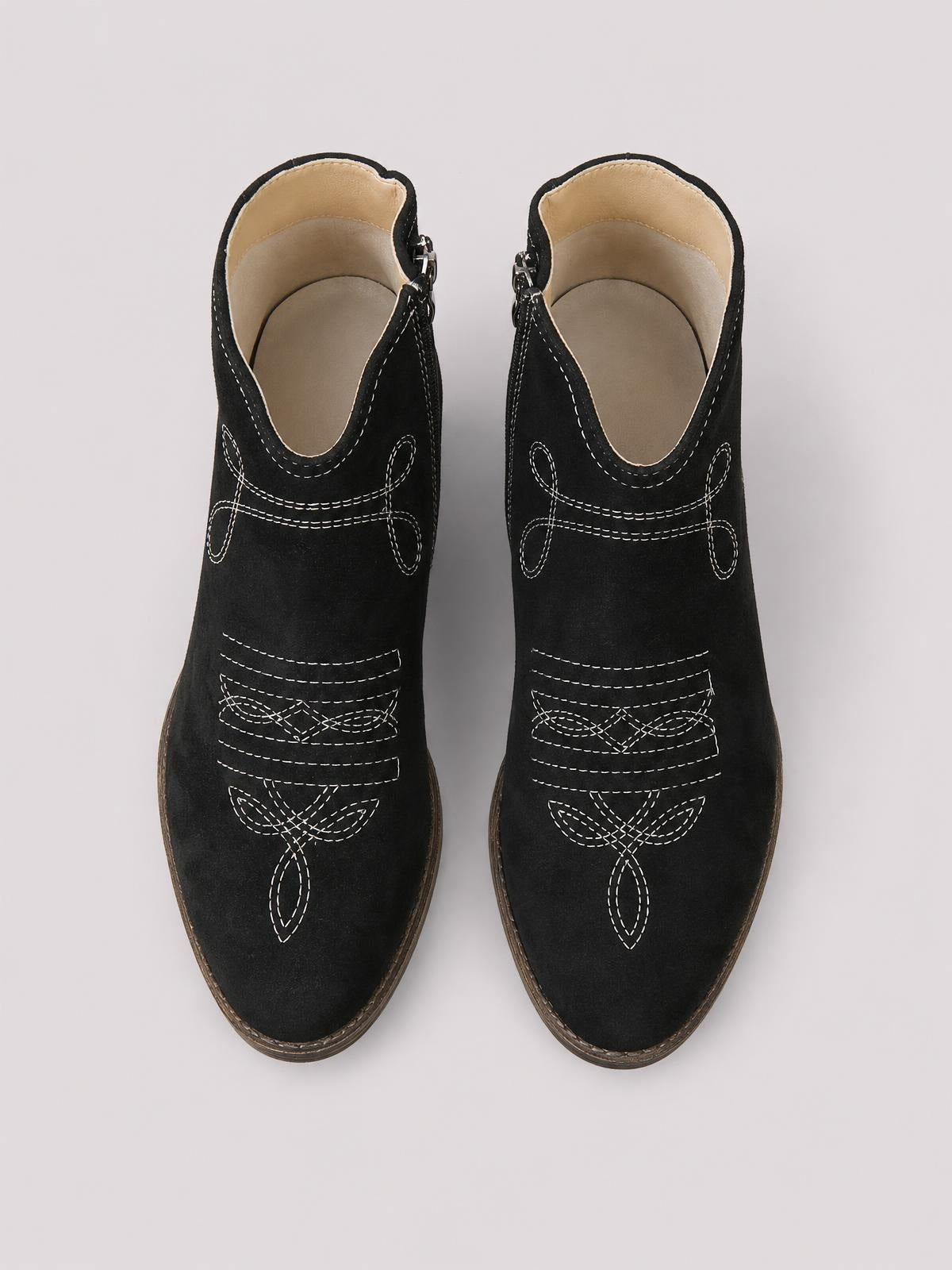 Pair of black ankle boots with contrasting white decorative stitching, rounded toes, side zippers, and mid-height block heels.