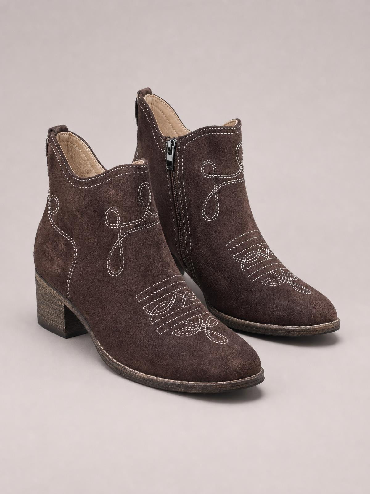 Brown PU leather ankle boots with mid block heels, rounded toes, side zippers, and contrasting white stitched Western-inspired detailing.