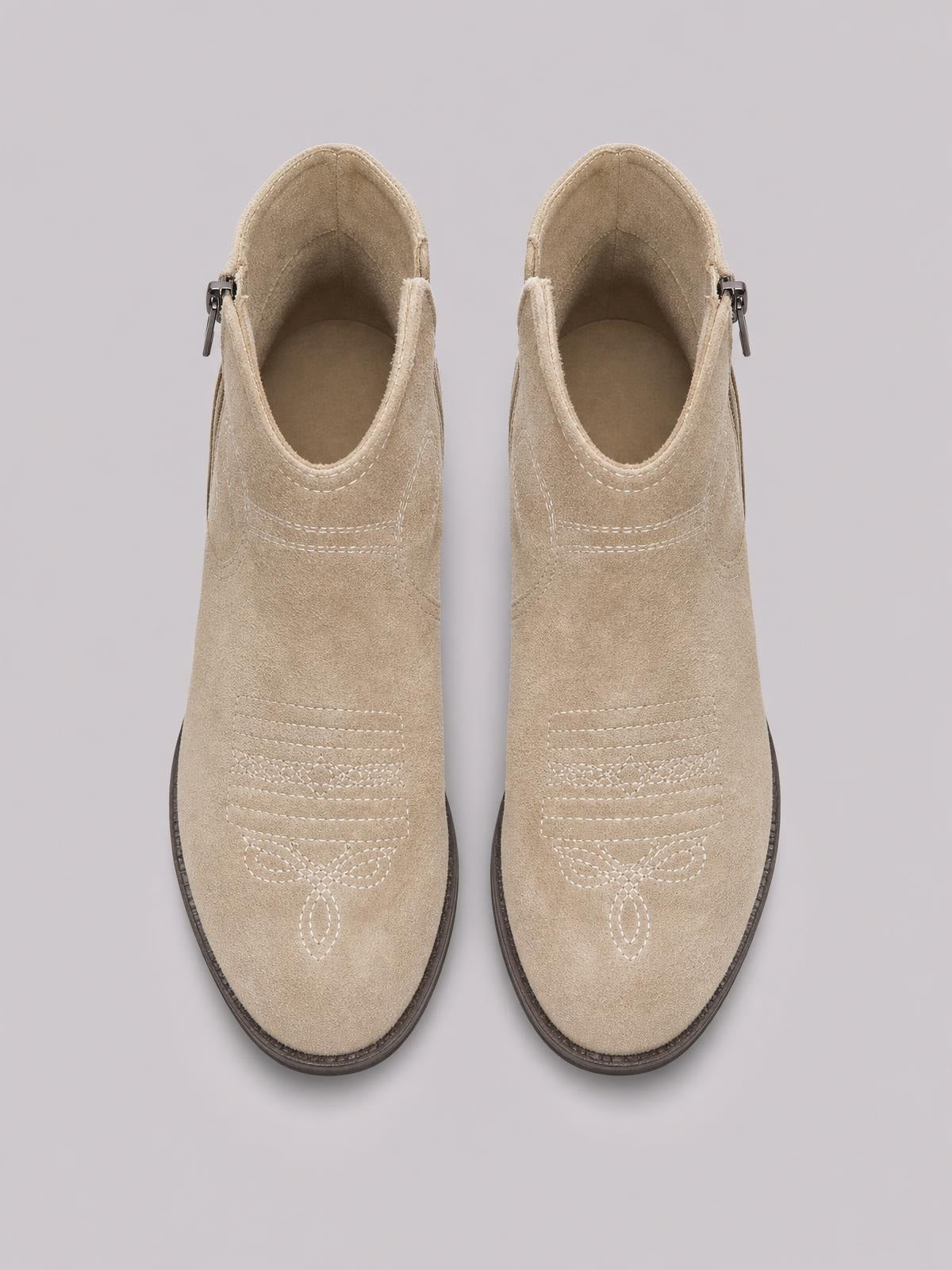 Pair of beige PU leather block heel ankle boots with side zippers, rounded toes, dark soles, and decorative stitched detailing.