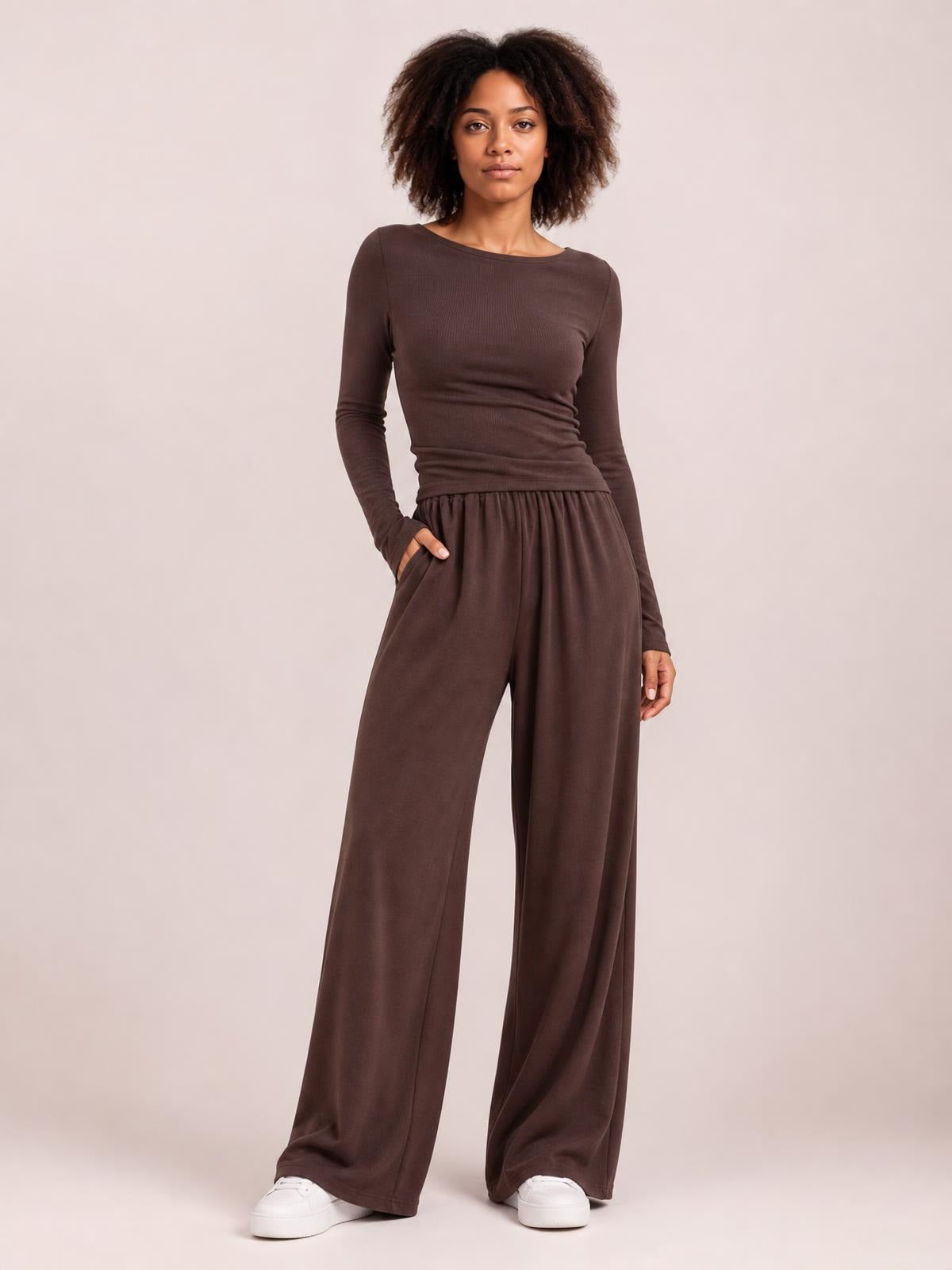 Model poses in a brown boat-neck long-sleeve top and coordinating wide-leg pants set, featuring a fitted silhouette, elastic waist, and side pockets.