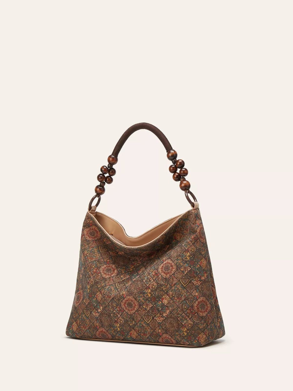 Medium bohemian hobo handbag in warm brown tones features an ornate geometric pattern, slouchy silhouette, and a rounded beaded shoulder handle.