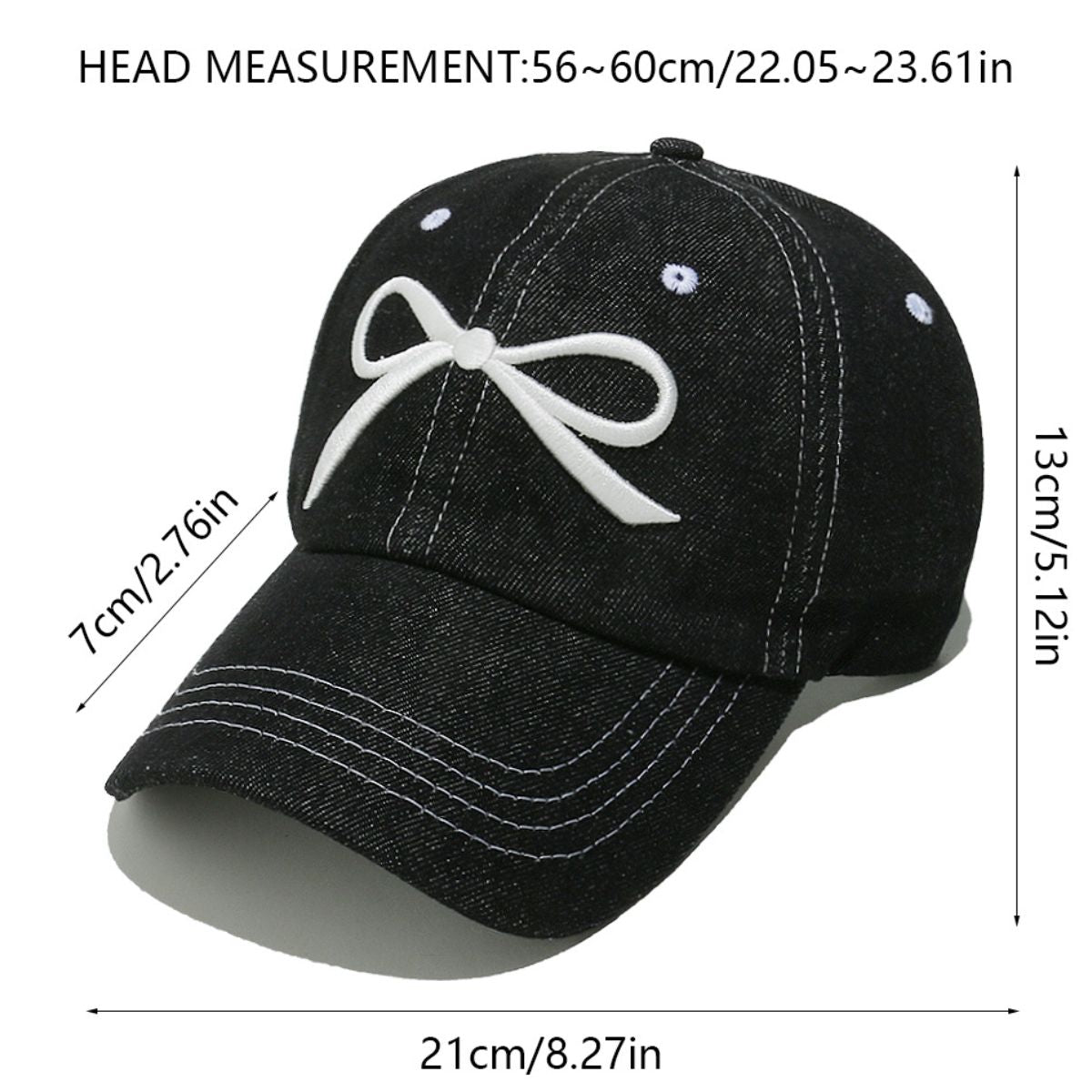 Black denim cotton baseball cap with a white embroidered bow, six-panel construction, curved brim, contrast topstitching, ventilation eyelets, and crown button.