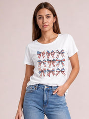 Model wearing a white round neck short sleeve T-shirt with a colorful bow graphic arranged across the front and a relaxed silhouette.