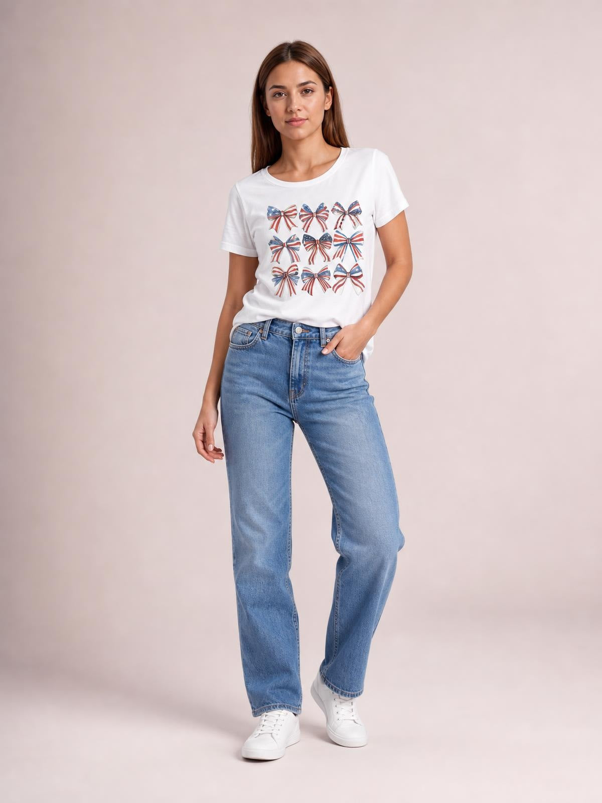 Model wearing a white bow graphic round neck short sleeve T-shirt with a relaxed silhouette, standing with one hand in her jeans pocket.