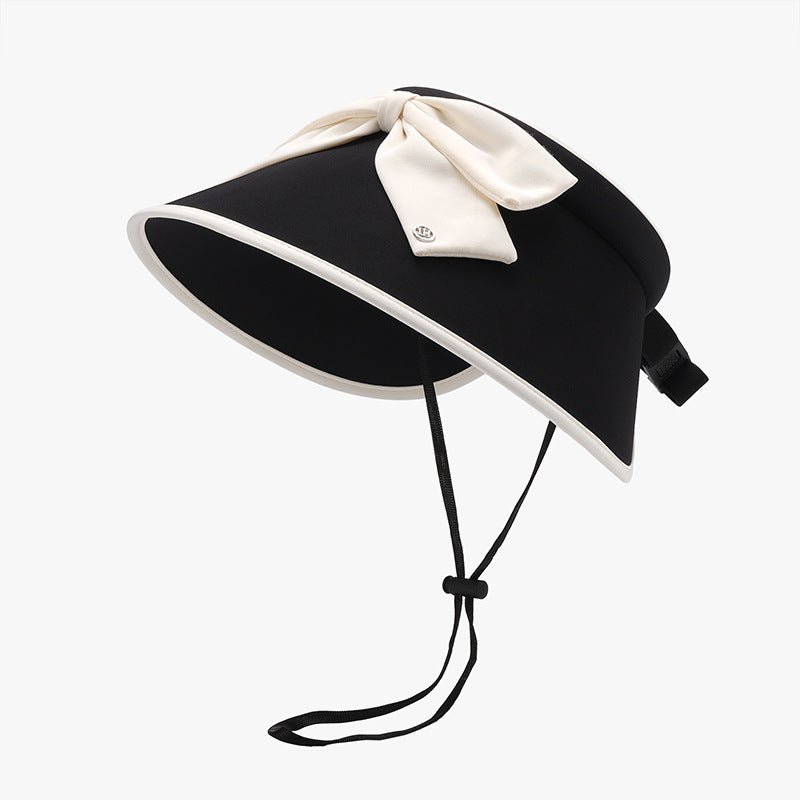 Black ice silk sun hat with a softly structured visor silhouette, wide curved brim, contrasting trim, statement cream bow, and adjustable under-chin cord.