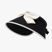 Black ice silk sun hat with a graceful visor-inspired silhouette, wide curved brim, contrasting cream trim, and a feminine bow accent on the crown.