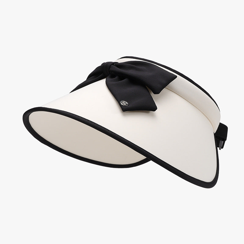 Cream ice silk sun hat with a wide visor-inspired brim, black edging, softly structured crown, and a prominent top bow for a polished silhouette.