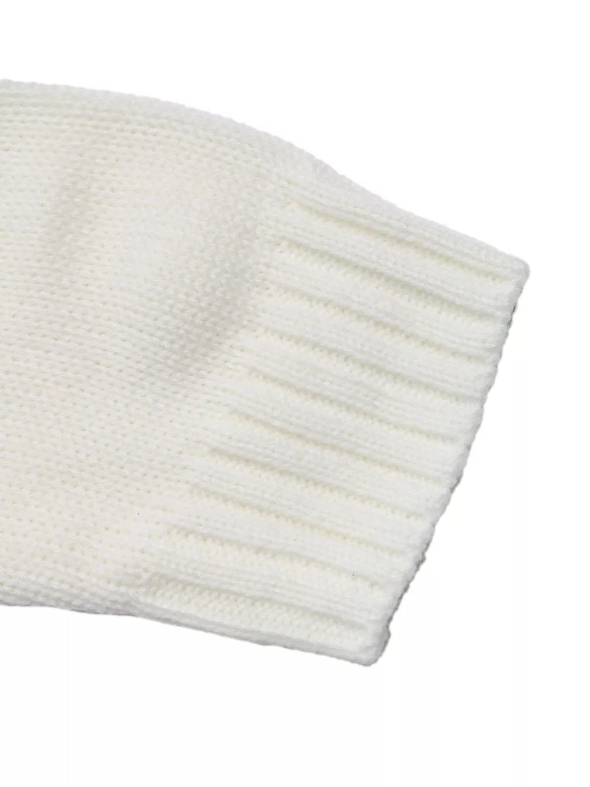 Close-up of a white knitted sweater sleeve with a structured ribbed cuff, showing the soft textured construction and long-sleeve design.