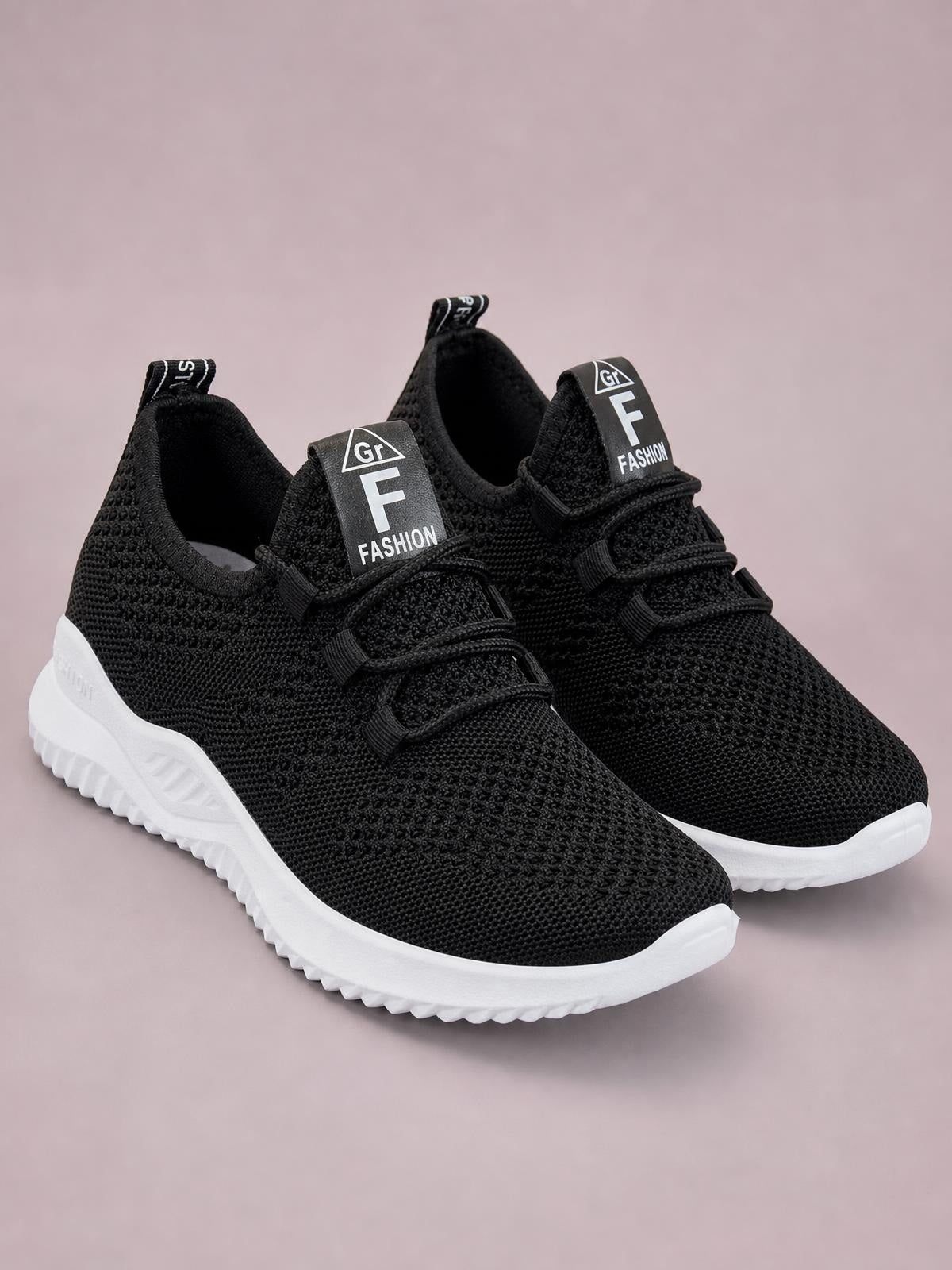 Pair of black breathable mesh lace-up athletic sneakers with textured uppers, low-top collars, pull tabs, and thick white rubber soles.
