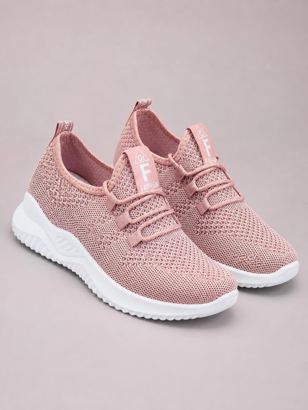 Pink breathable mesh lace-up athletic sneakers with a low-profile silhouette, textured uppers, padded collars, and thick white rubber soles.