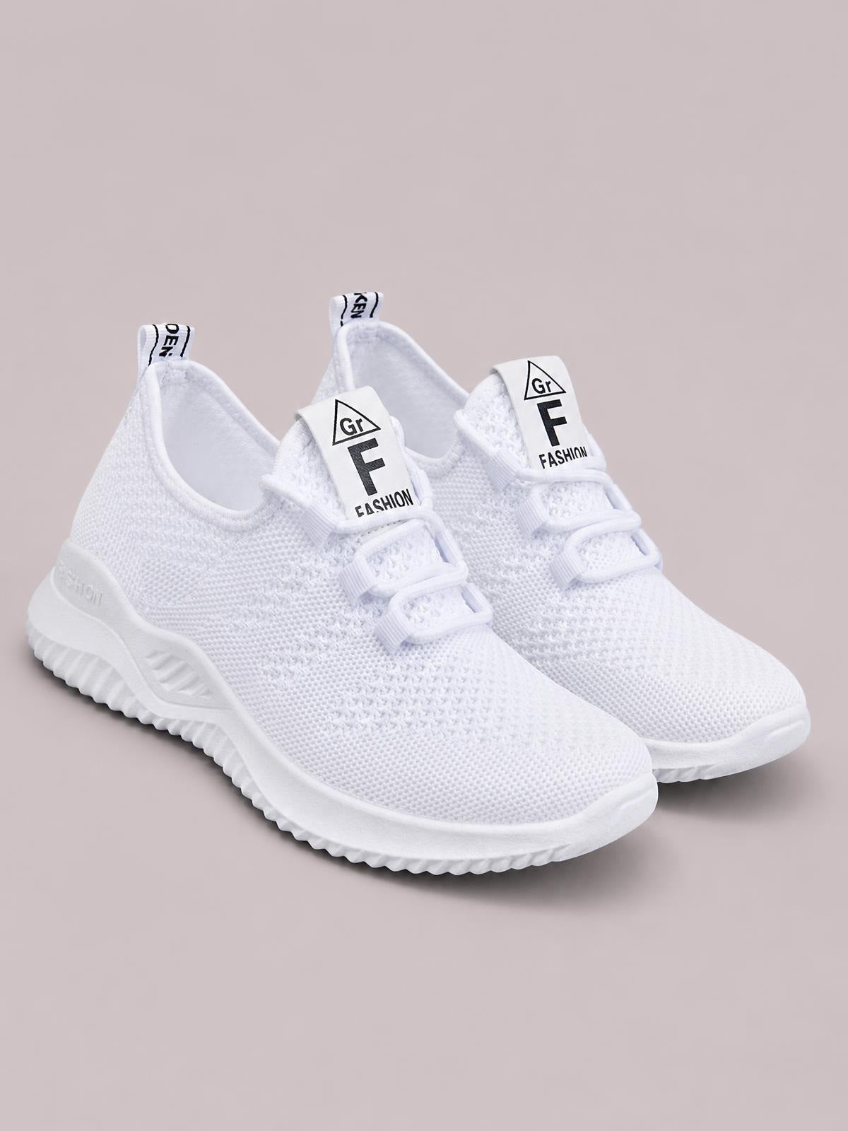 White breathable mesh athletic shoes with lace-up fronts, textured knit uppers, padded collars, pull tabs, and chunky flat rubber soles.