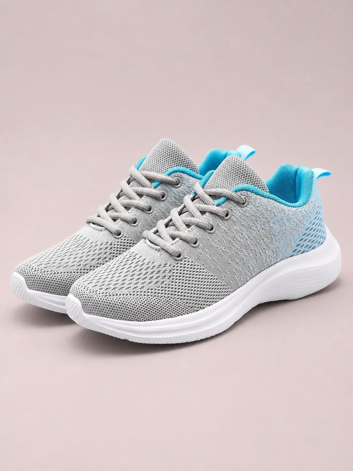 Pair of gray breathable mesh athletic shoes with round toes, gray laces, turquoise lining, and cushioned white rubber flat soles.