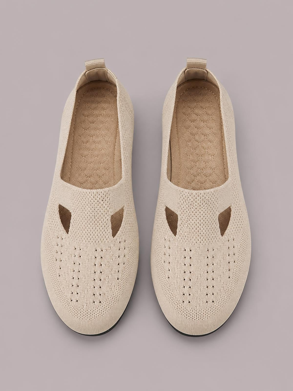 Beige breathable mesh round-toe flat slip-ons with woven construction, openwork panels, cushioned insoles, pull tabs, and black rubber soles.