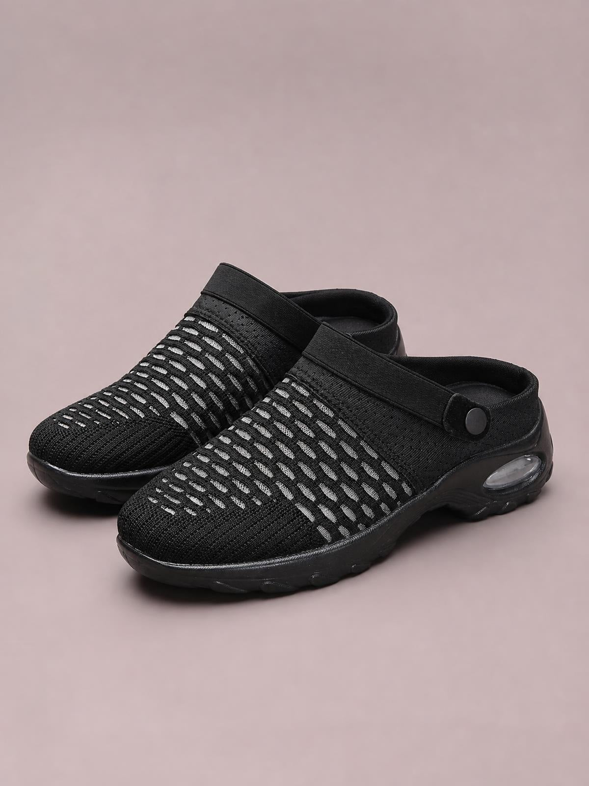 Pair of black breathable mesh round-toe sneakers with striped knit uppers, wide crossover straps, and chunky flat rubber soles.
