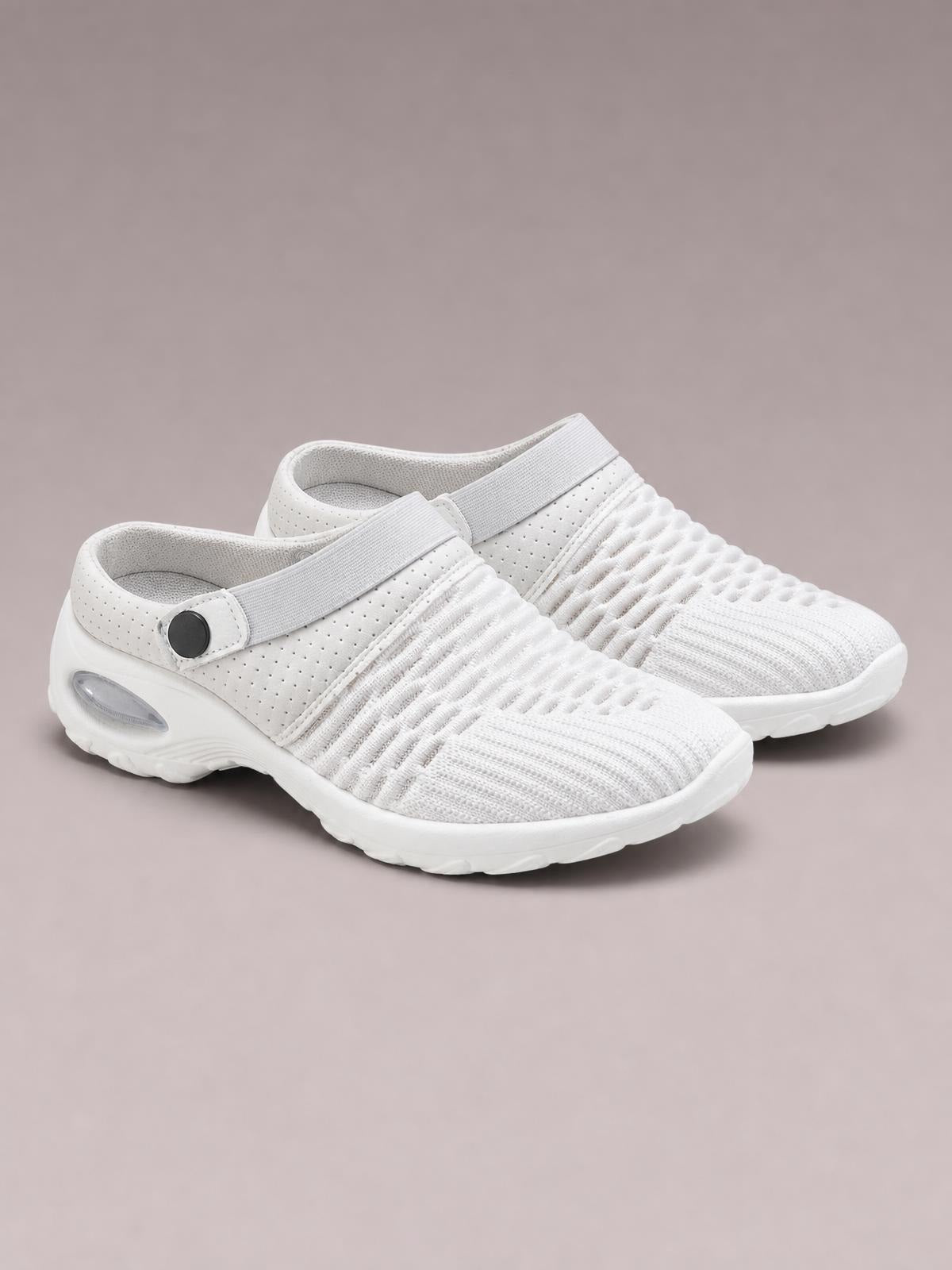 White breathable mesh round-toe sneakers feature a textured knit upper, elastic strap with button detail, cushioned flat rubber soles, and a streamlined silhouette.
