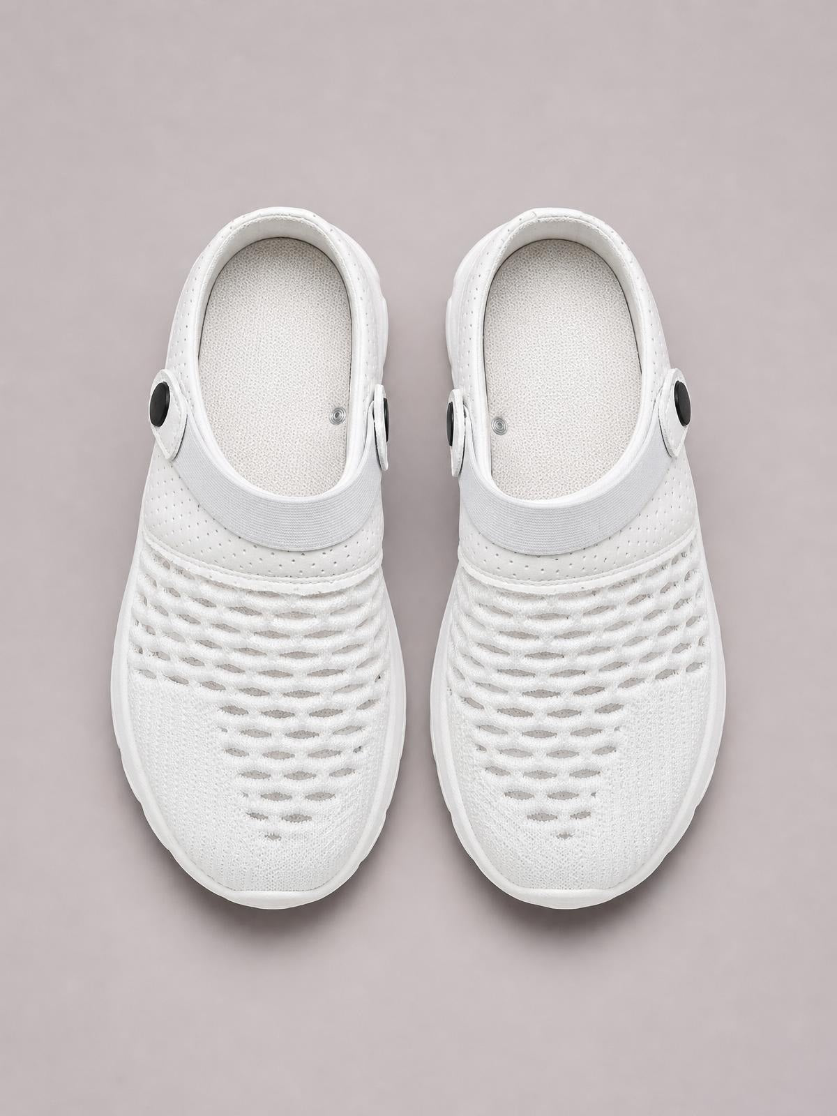 Pair of white breathable mesh sneakers shown from above, featuring round toes, perforated knit uppers, adjustable heel straps, and flat rubber soles.