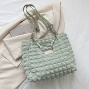 Mint green Bubble Textured Tote Bag with a raised tactile pattern, slender shoulder straps, linked chain accents, pearl-style strand, and front plaque.