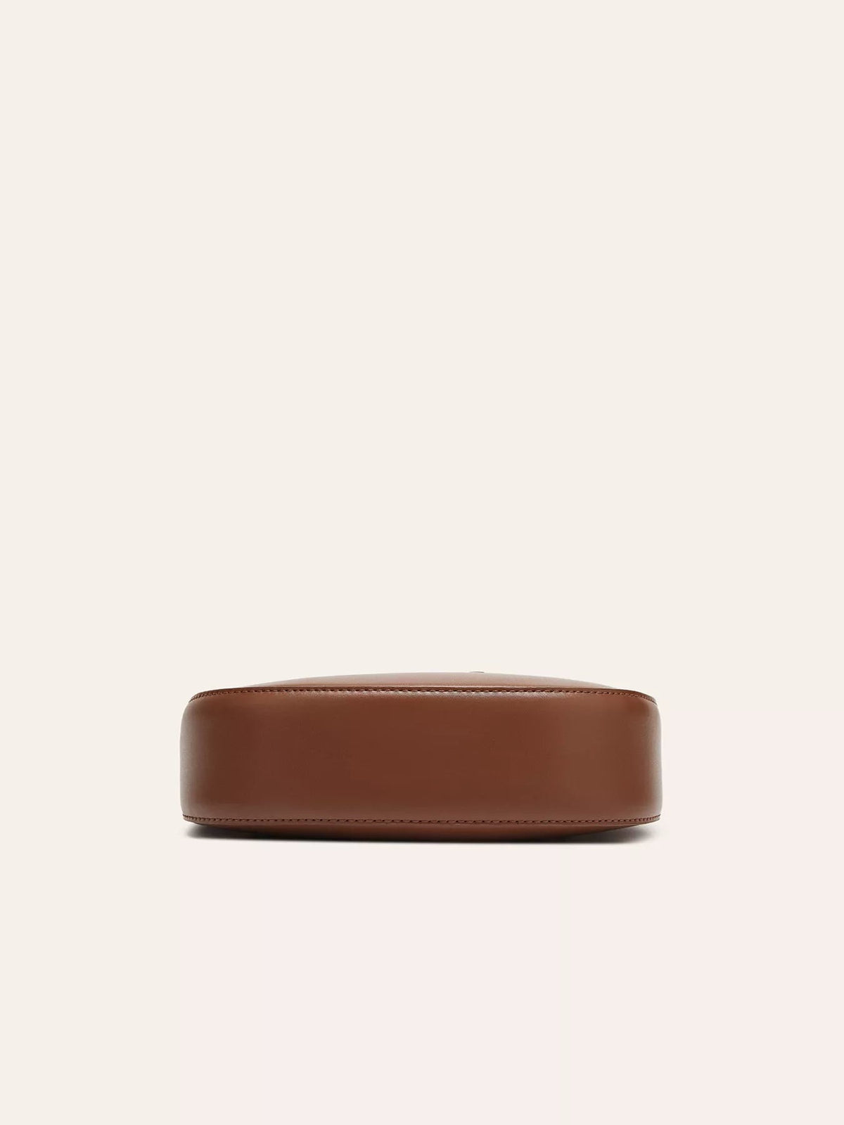 Small brown PU leather shoulder bag shown from below, featuring a structured rounded rectangular base with clean stitched edges and a smooth finish.