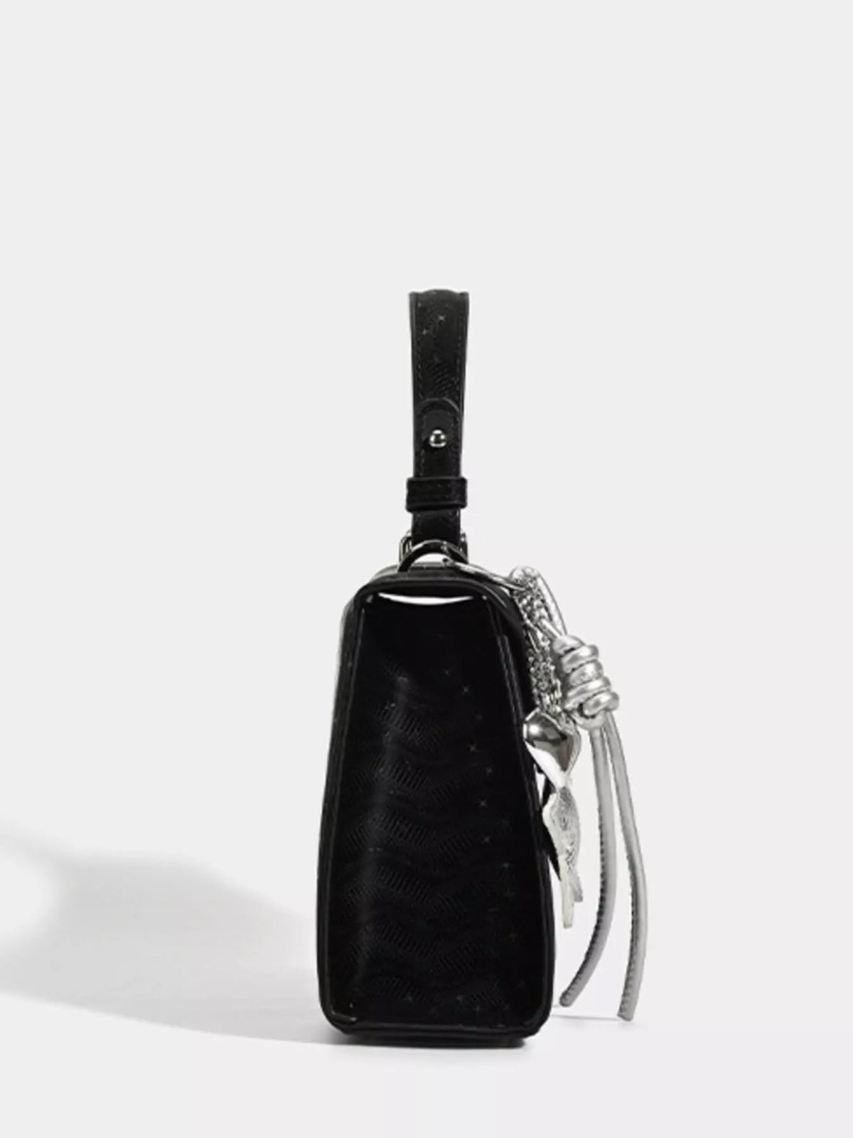 Black mini PU leather handbag with a structured rectangular silhouette, glossy finish, top wrist strap, silver side chain, and buckle-style strap detail.