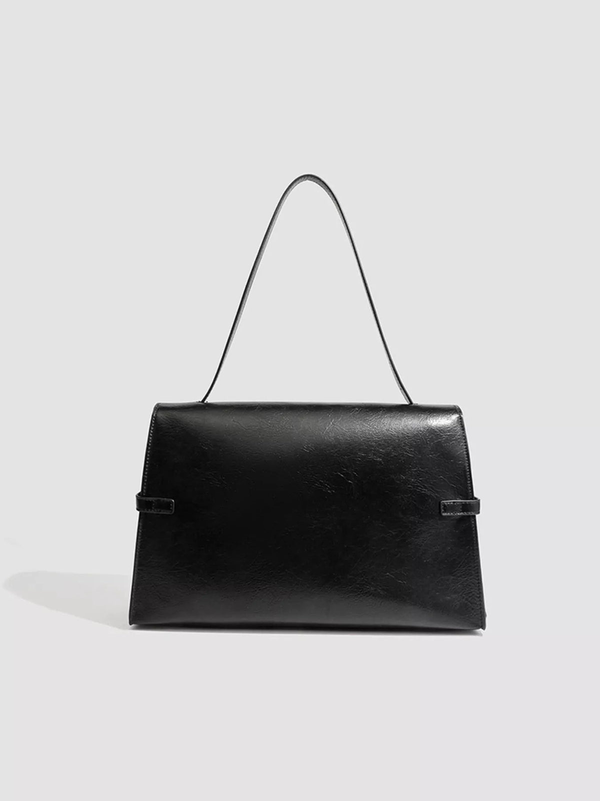 Black medium PU leather shoulder bag with a structured rectangular silhouette, long slim strap, smooth flap front, and side buckle strap details.
